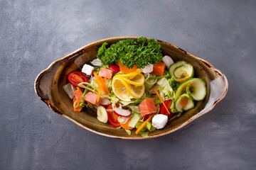 Tasty salad with salmon and fresh vegetables. Top view