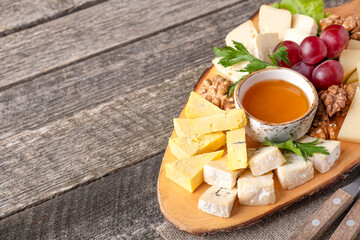 Cheese board with honey and grape. Rustic style. Copy space