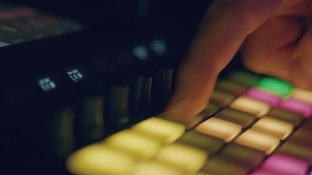 Musician playing synth sequencer
You can see the colored pads below that gently illuminate the hands of the musician who is in a dark environment