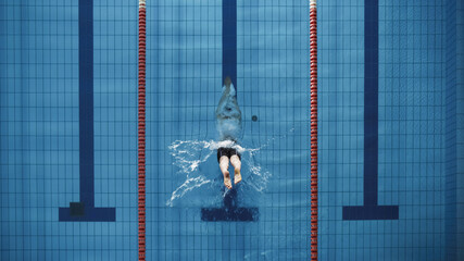 Aerial Top View Male Swimmer Jumping, Diving into Swimming Pool. Professional Athlete Winning World...