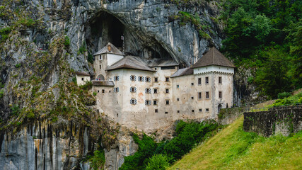 Fototapeta na wymiar Scenic view of Predjama castle at the cave mouth near Postojna, Slovenia at rainy summer day