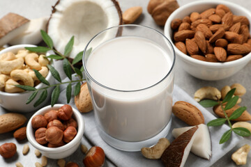 Vegan milk and different nuts on light table, closeup