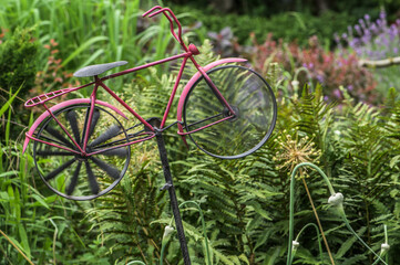 Windspiel in Form eines Fahrrads mit bewegtem Vorderrad in Bauerngarten