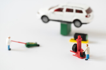 Miniature people Mechanic Labor Team changing car tire working in garage automobile service using for Car Automotive maintenance repair fixed or replacement Service or Vehicle Insurance guarantee 