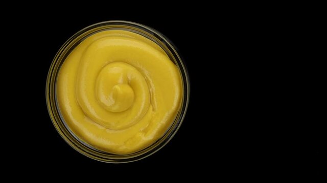 Mustard sauce isolated on background, rotating. 4K UHD video