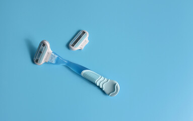 Shaving razor for women, on a blue background. Additional nozzle.