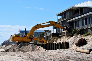 Backhoe working on beach erosion background at ocean beach St. Augustine, Florida.