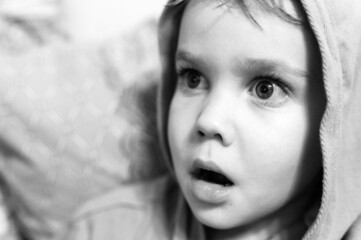 children's candid emotions on the face. portrait of a little boy with an expression of surprise or scared on his face. wide open eyes and mouth. tinted in black and white. noisy and grain effect