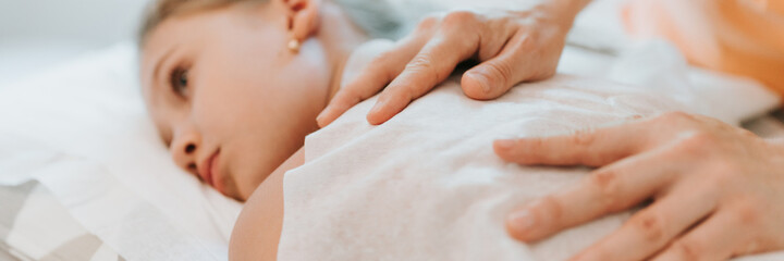doctor osteopath hands does physiological and emotional therapy for eight year old kid girl. pediatric osteopathy treatment session. alternative medicine. taking care of the child's health. banner