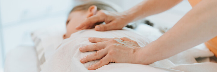 doctor osteopath hands does physiological and emotional therapy for eight year old kid girl....