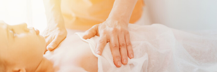 real doctor osteopath hands does physiological therapy for eight year old kid girl. pediatric osteopathy treatment session. alternative medicine. taking care of the child's health. banner. flare