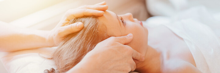 Fototapeta premium real doctor osteopath hands does physiological therapy for eight year old kid girl. pediatric osteopathy treatment session. alternative medicine. taking care of the child's health. banner. flare