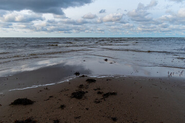 The Baltic Sea during a windy day. Waves crashing against the shore and sky reflection in the water.