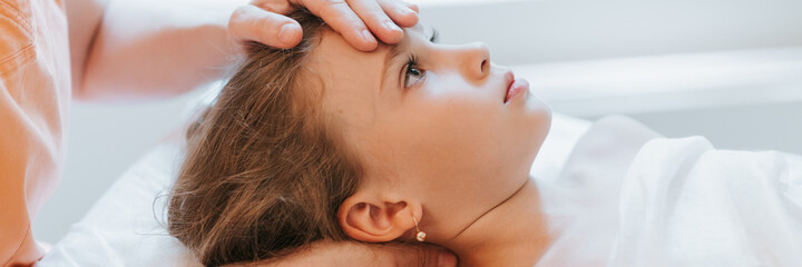 doctor osteopath hands does physiological and emotional therapy for eight year old kid girl....