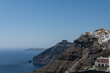 White top of buildings in Santorini, Greece with blue sky in a sunny warm day in July 2021.