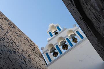 White top of buildings in Santorini, Greece with blue sky in a sunny warm day in July 2021.