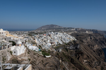 White top of buildings in Santorini, Greece with blue sky in a sunny warm day in July 2021.