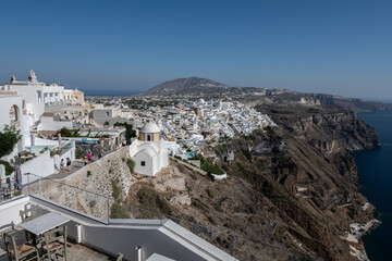 White top of buildings in Santorini, Greece with blue sky in a sunny warm day in July 2021.