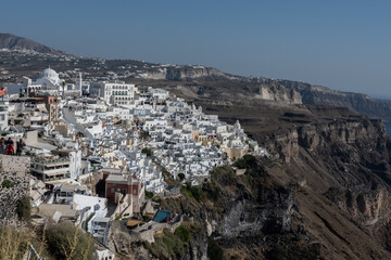 White top of buildings in Santorini, Greece with blue sky in a sunny warm day in July 2021.