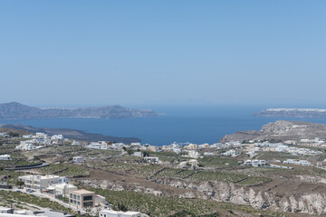 White top of buildings in Santorini, Greece with blue sky in a sunny warm day in July 2021.