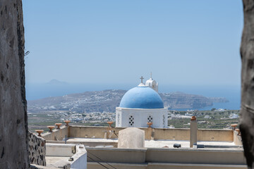 White top of buildings in Santorini, Greece with blue sky in a sunny warm day in July 2021.