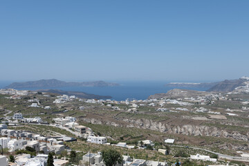 White and blue top of buildings in Pyrgos Santorini, Greece with blue sky in a sunny warm day in July 2021.