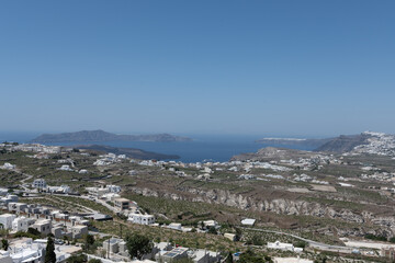 White and blue top of buildings in Pyrgos Santorini, Greece with blue sky in a sunny warm day in July 2021.
