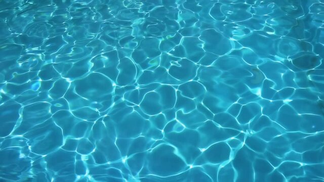 Abstract background of glittering azure water in pool