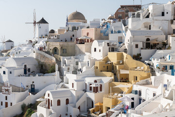 White and blue top of buildings in Pyrgos Santorini, Greece with blue sky in a sunny warm day in July 2021.