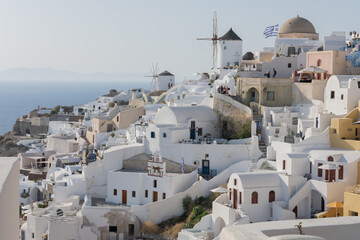 White and blue top of buildings in Pyrgos Santorini, Greece with blue sky in a sunny warm day in...