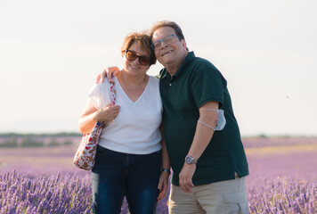 romantic lifestyle portrait of senior hispanic couple happy and relaxed at lavender flowers field enjoying retirement and celebrating aging together