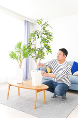 自宅で観葉植物を育てる中年の男性