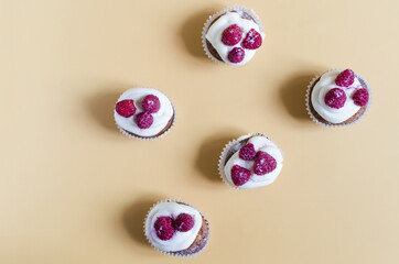 Homemade cupcakes with cream and berries on a colored background. Cake cupcake on a colored background top view is a place for text.