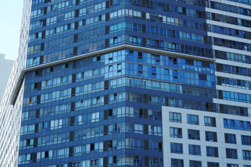  Facade of a modern high-rise glass building with open and closed windows.