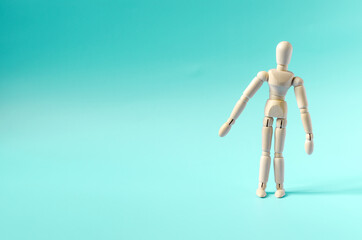 The figure of a surprised wooden man, on a light background. Dummy of a wooden man on a colored background copy space