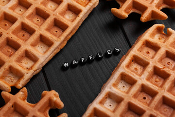 Fresh homemade Belgian waffles on an old table with inscription.