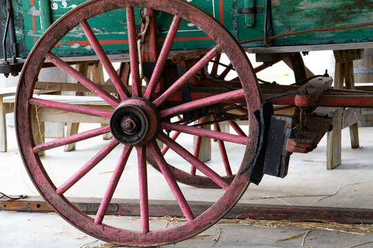 Close up of an old red hay wagon wheel and rubber brake