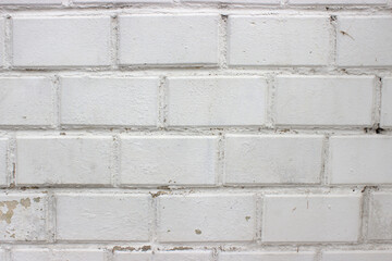 Background white brick wall close-up with peeling paint on the left side
