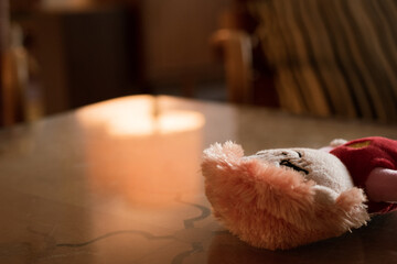 A shot of a doll on a table in a softly lit room