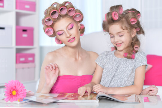 portrait of happy Mother and little daughter with hair curlers