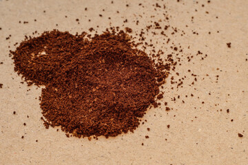brown coffee powder on light-colored recycled paper, close up photo