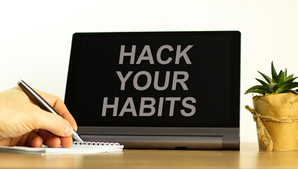Hack your habits symbol. Tablet with words 'Hack your habits'. Businessman hand with pen, house plant. Beautiful white background. Business, psychology and hack your habits concept, copy space. © Dzmitry