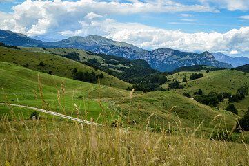 Fototapeta na wymiar Beautiful Landscape with Trees, Mountains and Meadows with a Blue Sky and Clouds Seen on the Mountains from Passo Fittanze Di Sega, in Lessinia, near Verona in Italy