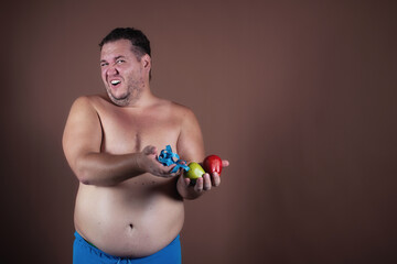 Funny fat man and diet. Brown background.