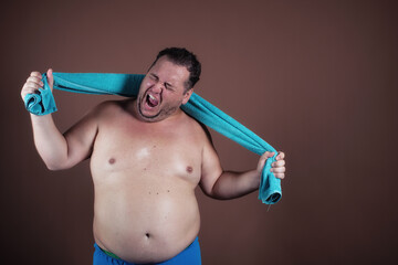 Funny fat man in the shower. Brown background.