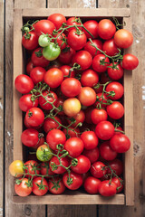 Red cherry tomatoes in a wooden box.
