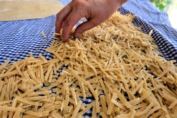 Preparing process of homemade Turkish noodle, selective focus. Noodles are the pasta that Turkish women make. It is called "Eriste", "Makarna" or "Kesme" in Turkish. Yeast dough dry with sun.