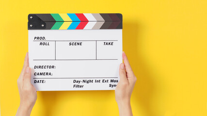 Hand is holding clapper board or movie slate or film slate.It is used in video production and...
