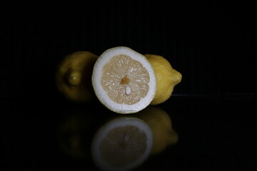 Lemons on black reflective surface