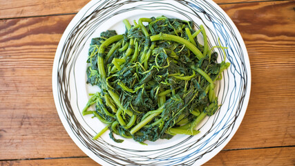 Amaranthus blitum. Vlita Salad (Amaranth Greens) on a plate, on a wooden old table